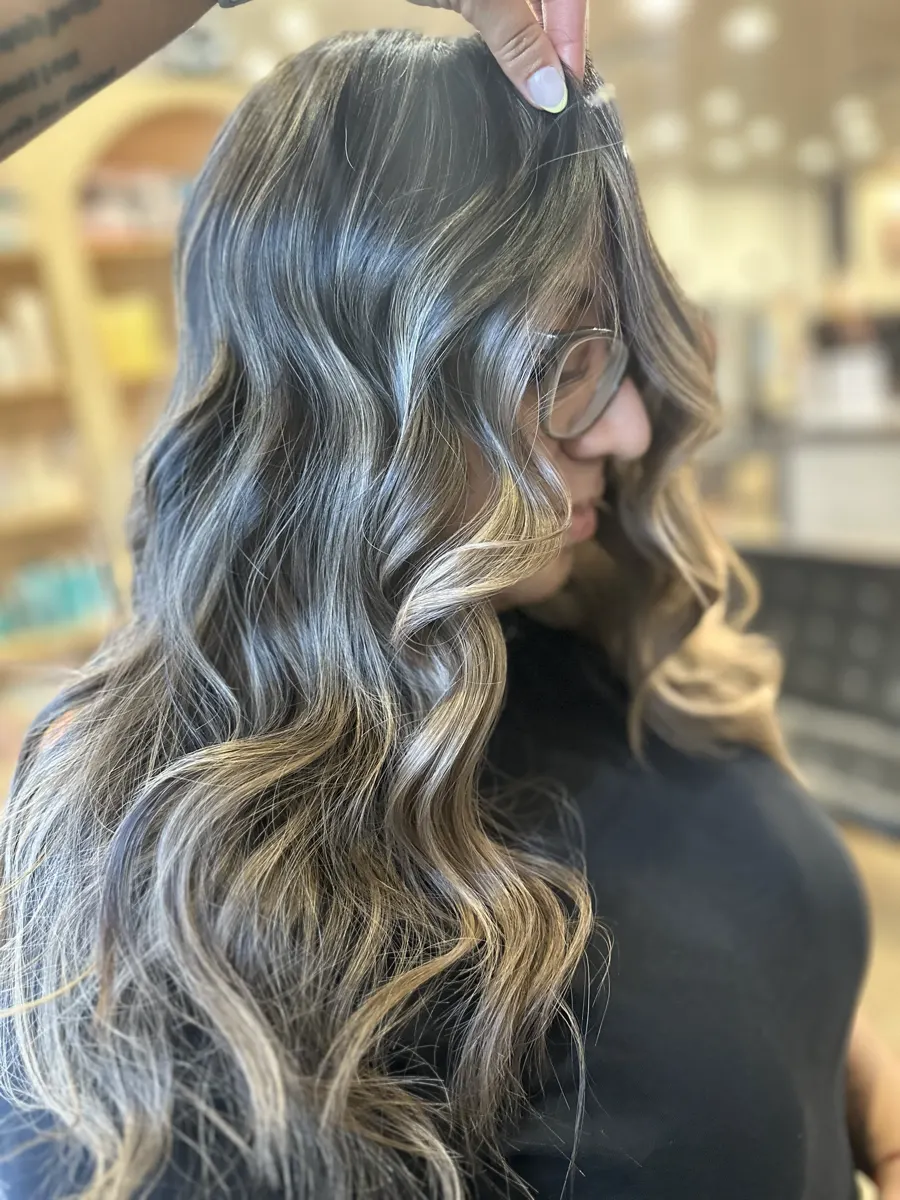 Balayage blond lumineux sur cheveux ondulés, réalisé au Studio Délia